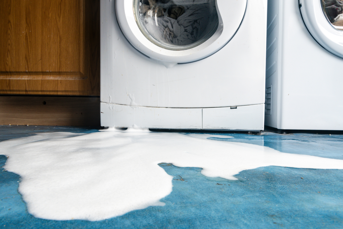 Washing machine leaking soapy water onto the floor after repeated unbalanced spin cycles